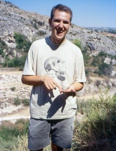 El autor del hallazgo, Antonio López, posa con el bifaz en la Cueva Negra de Caravaca